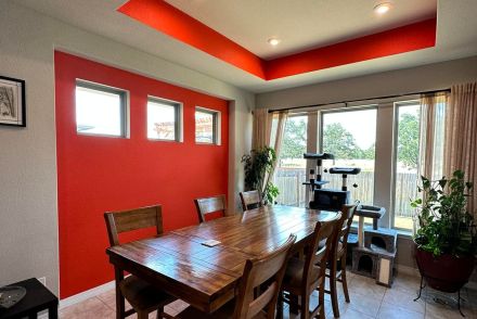 Contemporary interior with a vibrant red entrance door and stairs, showcasing minimalist design.